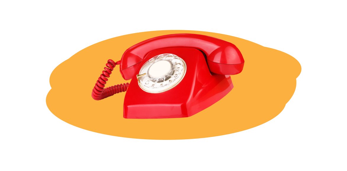 Na żółtym tle czerwono-biały telefon z tarczą obrotową i słuchawką